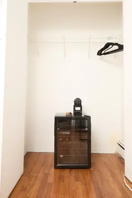 a glass cabinet in a room with a wooden floor at American Dream Guest House in New York
