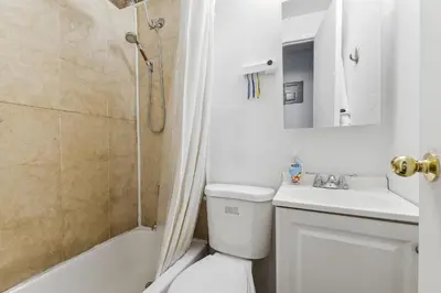 a bathroom with a toilet and a sink and a shower at American Dream Guest House in New York