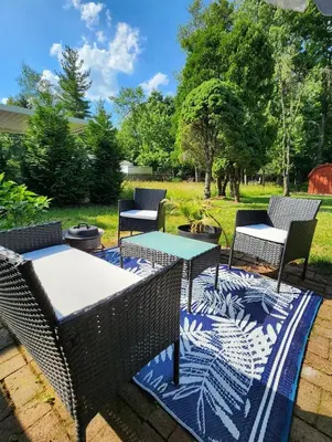 a patio with chairs and tables on a blue rug at Chic Spacious Apt Near Attractions/Food/EWR/NYC in West Orange