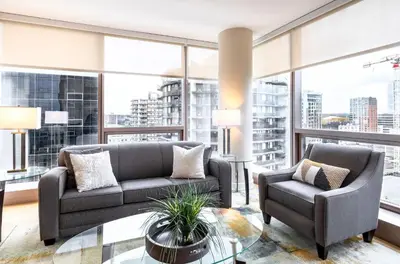 a living room with two couches and a glass table at Spacious Apartment Downtown in Stamford
