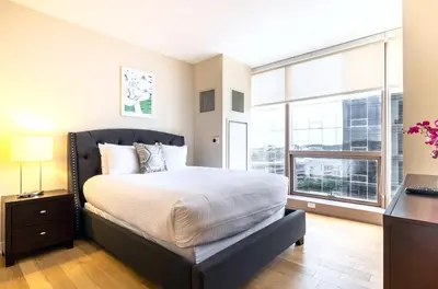 a bedroom with a large bed and a large window at Spacious Apartment Downtown in Stamford