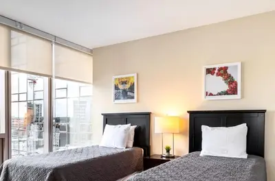 two beds in a room with a window at Spacious Apartment Downtown in Stamford