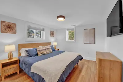 a bedroom with a bed and a flat screen tv at Lakeside, Dock, Hot Tub, Kayaks, Arcade, Playset in Lake Ariel