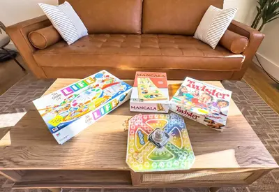 a coffee table with games on it in front of a couch at Lakeside, Dock, Hot Tub, Kayaks, Arcade, Playset in Lake Ariel