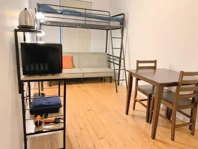 a room with a desk and a bunk bed with a table at Shered bathroom 4 SofaBed + loftbed + kitchen in New York