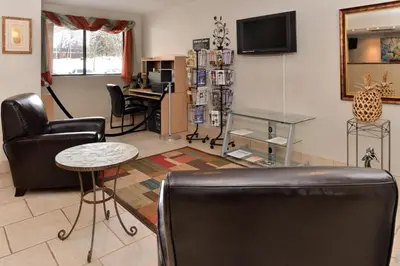 a living room with black leather chairs and a table at Americas Best Value Inn New Paltz in New Paltz