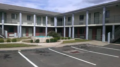 an empty parking lot in front of a building at Branford Motel in Branford