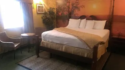 a bedroom with a bed and a table and a window at Branford Motel in Branford