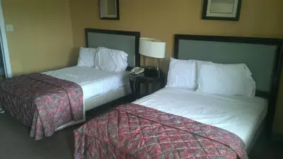 a hotel room with two beds and a lamp and a phone at Branford Motel in Branford