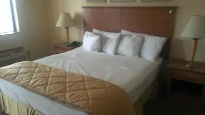 a bedroom with a bed with white sheets and pillows at Branford Motel in Branford