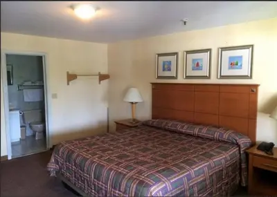 a hotel room with a bed and a bathroom at Branford Motel in Branford