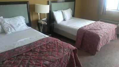 a hotel room with two beds and a lamp at Naugatuck Motor Lodge in Naugatuck