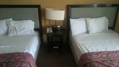 a hotel room with two beds and a table with a lamp at Naugatuck Motor Lodge in Naugatuck