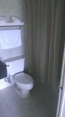 a bathroom with a white toilet and a shower curtain at Naugatuck Motor Lodge in Naugatuck