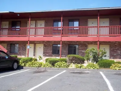 a parking lot in front of a large building at Naugatuck Motor Lodge in Naugatuck