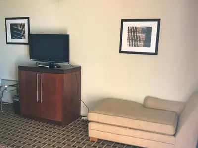 a living room with a couch and a tv on a cabinet at Grantmoor Motor Lodge in Newington