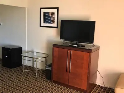 a flat screen tv sitting on top of a wooden cabinet at Grantmoor Motor Lodge in Newington