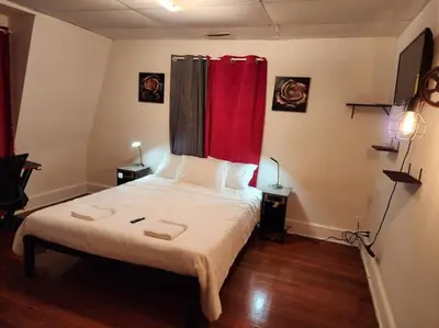 a bedroom with a bed with a red curtain at spacious and indulging in Meriden