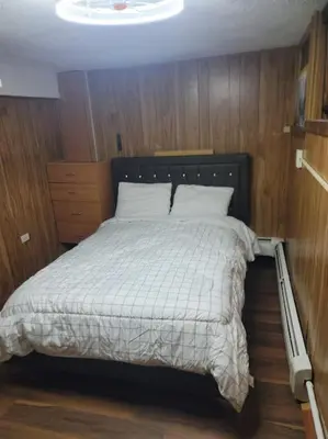a bedroom with a bed with a white comforter at The Subterranean Haven in Mount Vernon