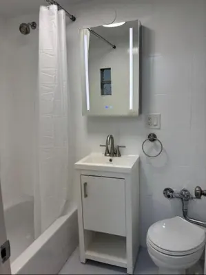a bathroom with a sink and a toilet and a mirror at Oasis Retreat - Cozy studio in Union Square in New York