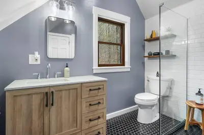a bathroom with a toilet and a sink and a mirror at Lakefront Log Cabin, Private Lake Access w/Peloton in Livingston Manor