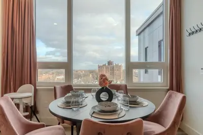 a dining room with a table and chairs and a window at Rosy Retreat with NYC Views by the train, Free Parking, 3 beds, 20 Percent OFF 7 days in Newark
