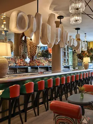 a bar with chairs and cups hanging above it at Warren Street Hotel in New York