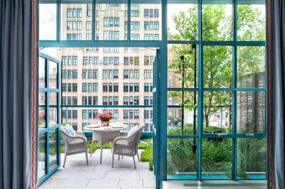 a balcony with a table and chairs looking out onto a building at Warren Street Hotel in New York