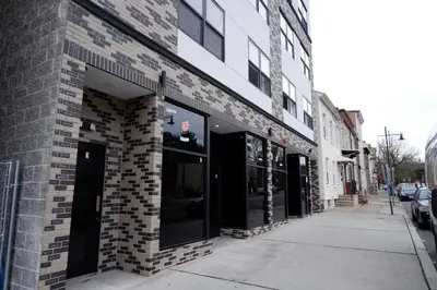 a brick building with large windows on a street at The Cozy Suite - 1BR with Free Parking in Paterson