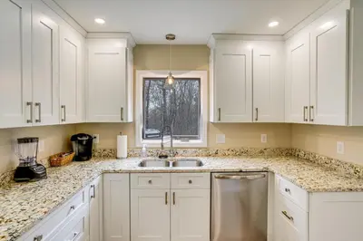 a kitchen with white cabinets and a sink and a window at Catskills Winter Getaway with Game Room in East Durham