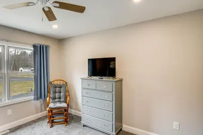 a bedroom with a dresser with a tv and a chair at Catskills Winter Getaway with Game Room in East Durham