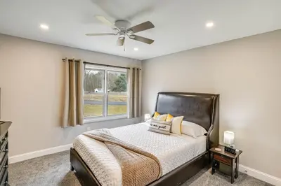 a bedroom with a bed with a ceiling fan at Catskills Winter Getaway with Game Room in East Durham