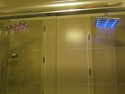 a shower with a glass door with blue lights at Cherry Valley Manor in Stroudsburg