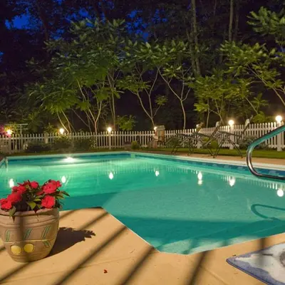a swimming pool at night with a vase of flowers at Cherry Valley Manor in Stroudsburg
