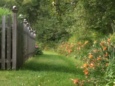 a wooden fence in a yard with flowers at Deerhill Inn in West Dover