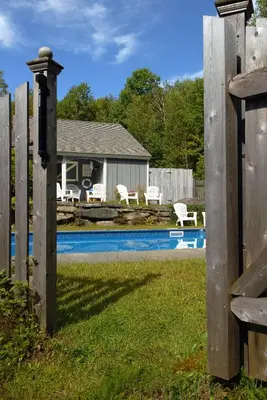 a fence with a pool in front of a house at Deerhill Inn in West Dover
