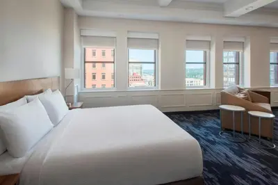 a bedroom with a large white bed and windows at Fairfield Inn & Suites by Marriott Albany Downtown in Albany