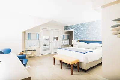 a bedroom with a large bed with a blue accent wall at Danfords Hotel & Marina in Port Jefferson Station