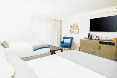 a hotel room with two beds and a flat screen tv at Danfords Hotel & Marina in Port Jefferson Station