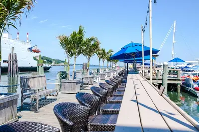 a dock with chairs and umbrellas next to the water at Danfords Hotel & Marina in Port Jefferson Station
