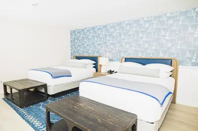 a room with two beds and a table in it at Danfords Hotel & Marina in Port Jefferson Station