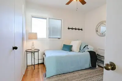 a bedroom with a blue bed and a window at Cheerful 3 Bedroom Beach Front Cottage with Fire Place in Milford