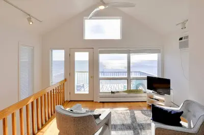 a living room with two chairs and a television at Cheerful 3 Bedroom Beach Front Cottage with Fire Place in Milford