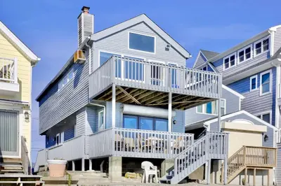 a large house with a deck on the side of it at Cheerful 3 Bedroom Beach Front Cottage with Fire Place in Milford