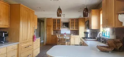 a large kitchen with wooden cabinets and a table at Escape to the Catskills in Liberty