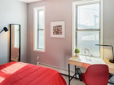 a bedroom with a desk and a red bed at Spacious Getaway by Wooster Square! in New Haven