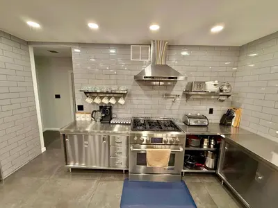 a large kitchen with a stainless steel counter top at Ultimate Luxury Villa - Pool, Sauna, Hot Tub & More in Paterson