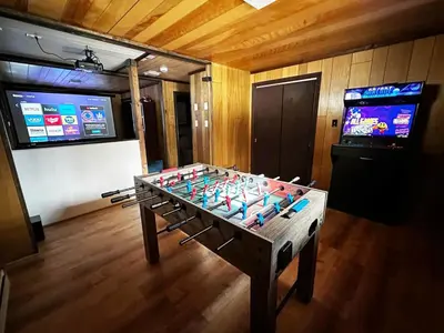a foosball table in a room with a tv at Crooked Ear Cabin in Wilmington