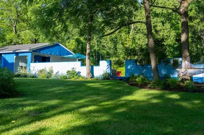 a yard with a blue building and a grass field at Spacious 4bd Country Gem - Fire Pit & Chill Vibes in Highland