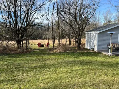 two cows grazing in a field next to a house at Country Cottage with beautiful views in Saugerties